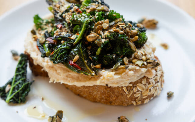 WINTER GREENS and SESAME CHILLI ON TOAST. Sauteed winter greens, chilli oil, mixed seed dukkah & smashed white beans on toasted bloomer bread.