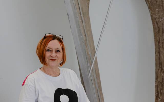 Person standing in front of a large metal sculpture